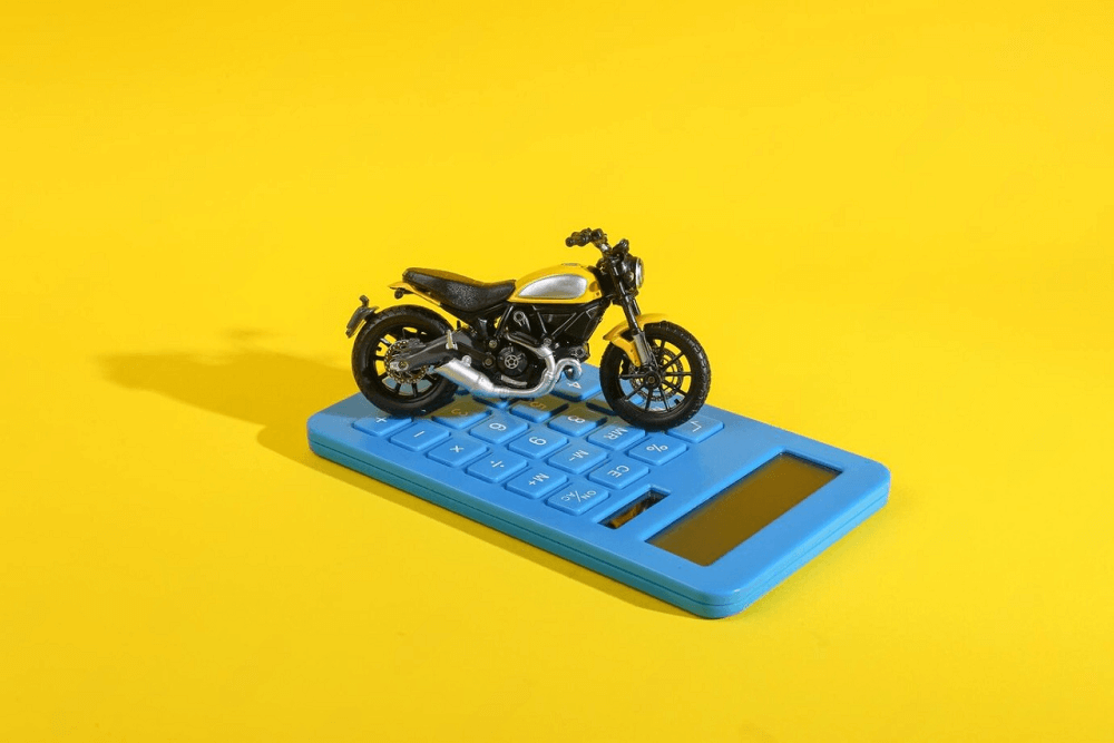 toy-motorcycle-with-calculator-yellow-background-calculating-cost-fuel-costs-buying-motorcycle_175682-44203